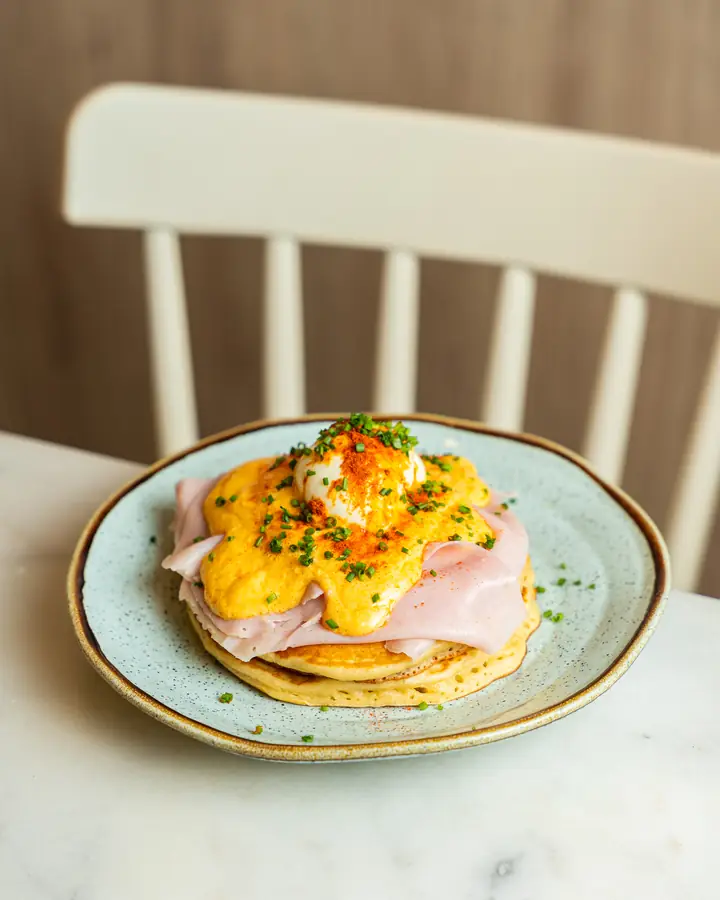 Ovos Benedict com fiambre e molho holandês sobre panqueca